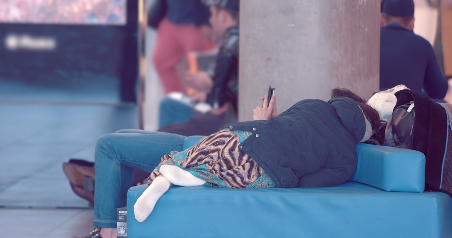 Tired passengers sleeping on sofas waiting for departure fron the airport