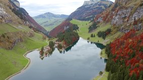 4K aerial - a bird's eye view video (Ultra High Definition). Splendid autumn view of Seealpsee lake. Picturesque morning scene of Swiss Alps. Beauty of nature concept background.