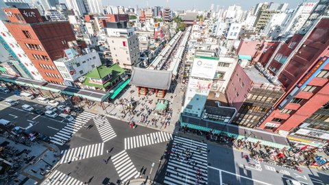 Tokyo, Japan - Nov 4, 2019: time-lapse of people walking, car transportation in Asakusa, Senso-ji temple, Kaminarimon and Nakamise road. Tokyo landmark, Japan travel, or Japanese city life. Zoom out