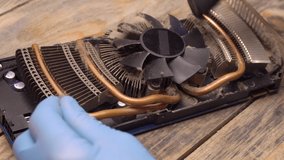 wizard removes dust from video card fan with brush and vacuum cleaner.