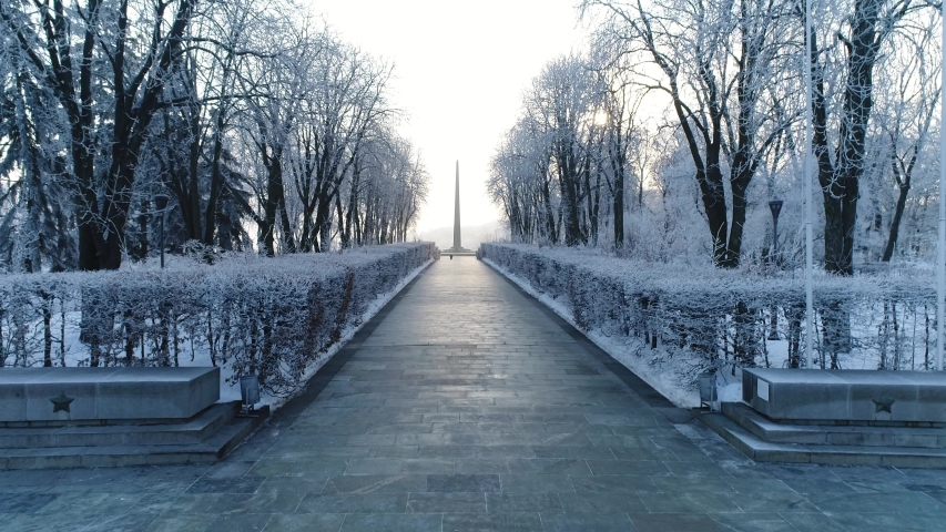 Aerial drone flight view of Soviet spire and fire monument of USSR victory in Great Patriotic war in Eternal glory park in Kiev frosty cold ice snow winter morning. Russian symbol of Second world war