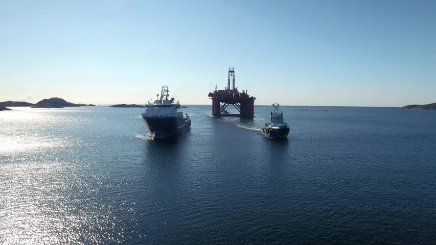 Offshore oil rig pulled by tugboats in beautiful weather. Royalty-Free Stock Footage #1041588448