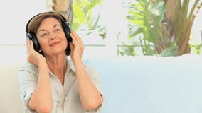 Mature woman listening to music in the living room