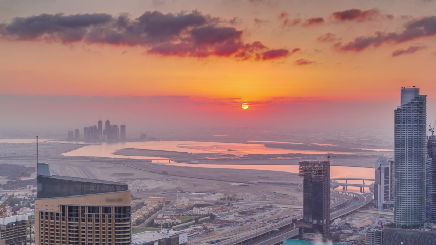 Amazing sunrise aerial view of Dubai downtown skyscrapers morning timelapse with haze, Dubai, United Arab Emirates. Modern towers and construction site