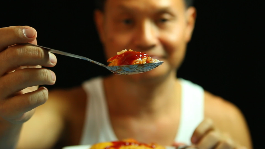 Thai man eating omelet , in studio  Chiangmai Thailand