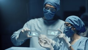 Professional Surgeon and Assistant Analyze Patient Lung Diagnosis Data on Transparent Devices During Surgery. Modern Hospital Operating Room. Shot on RED Epic-W Helium Camera. - Powered by Shutterstock - Get 15% off with code: PIKWIZARD15