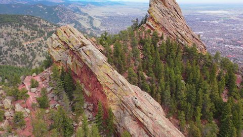 Aerial: Drone moving over rocky mountain by city against sky - Boulder, Colorado