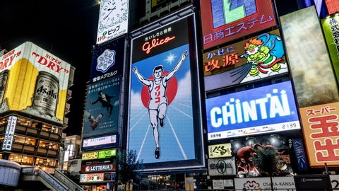 OSAKA, JAPAN - JUN 29, 2019: Glico Running Man billboard and other Illuminated signboards at Ebisubashi Bridge on the Dotonbori Canal. The Osaka's famous tourist landmarks at Dotonbori area.
