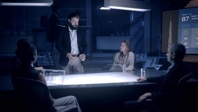 In the Near Future: Businessman in Suit presenting Architecture Project to Colleagues and Partners sitting around Futuristic Table with Holographic Modern Augmented Reality Technology. - Powered by Shutterstock - Get 15% off with code: PIKWIZARD15