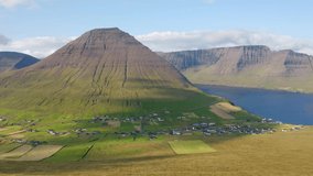 4k drone forward video (Ultra High Definition). Perfect summer scene of Vidareidi village, Vidoy island. Wonderful morning view of Faroe Islands, Kingdom of Denmark, Europe.