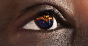 Woman black eye in close up with the flag of Arizona state in iris, united states of america with wind motion. video concept