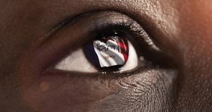 Woman black eye in close up with the flag of Iowa state in iris, united states of america with wind motion. video concept