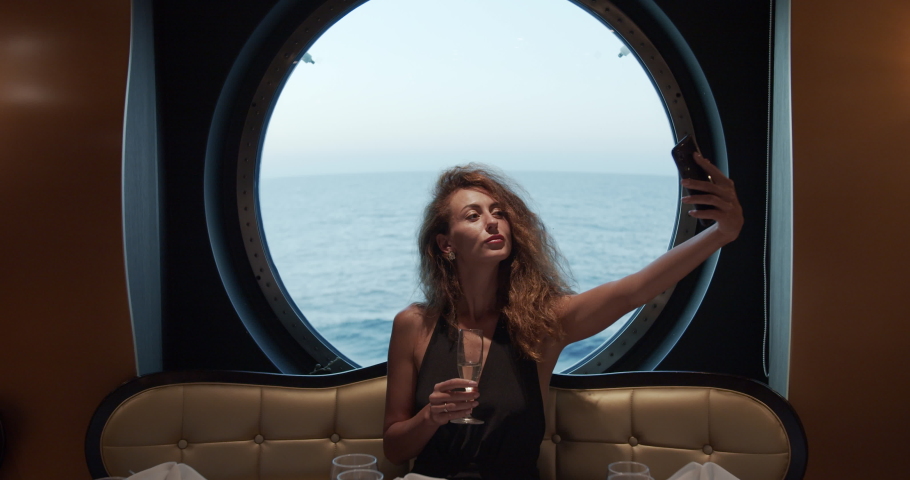 Bautiful girl in evening dress taking a selfie in the restaurant..