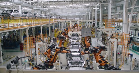 BELARUS, BORISOV - AUGUST 7, 2019: Automobile plant, modern production of cars, car body welding process, robots at work, build process in automated production line, 4k 50fps.