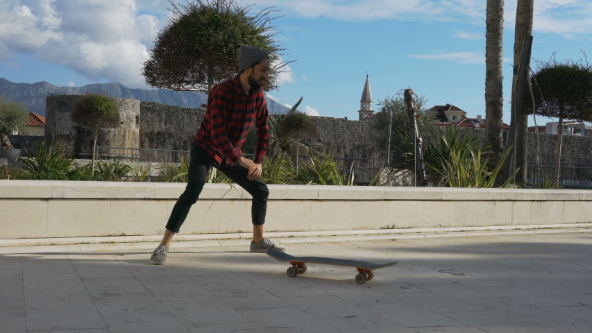 young male skateboarder warming up before tricks and then perform a few tricks