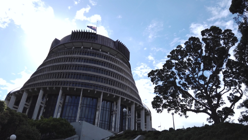 New Zealand government building flying flag at half mast after national disaster, slow motion establishing shot