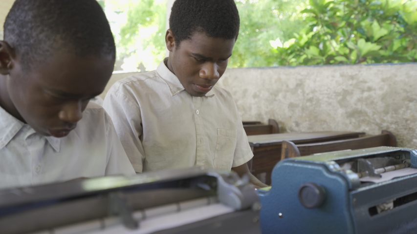  Teacher of disabilities with blind student in classroom.
