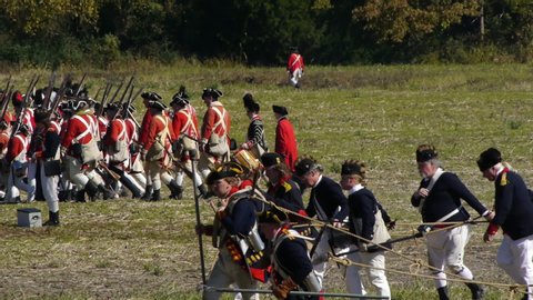 VIRGINIA - OCTOBER 16, 2018 - large-scale, epic American Revolutionary War anniversary reenactment -- in the middle of battle. British Army Redcoat infantry volleys and fires in line of battle.