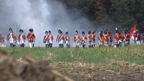 VIRGINIA - OCTOBER 16, 2018 - large-scale, epic American Revolutionary War anniversary reenactment -- in the middle of battle. British Army Redcoat infantry volleys and fires in line of battle.