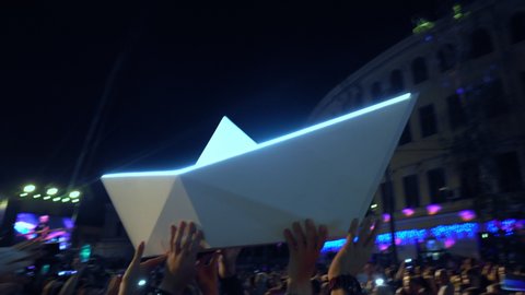Ukraine, Kyiv, July 19, 2019: Free concert. Fans pass from hand to hand a large paper boat. Happy people are watching an amazing musical concert.  Live concert.