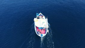 Aerial drone video of traditional wooden fishing boat in old port of Mykonos island,  Cyclades, Greece