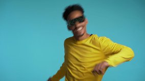 African american man in glowing glasses dancing with hands isolated on blue background. Party, music, lifestyle, radio and disco concept.