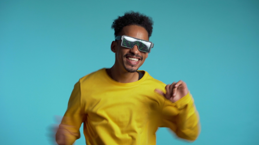 African american man in glowing glasses dancing with hands isolated on blue background. Party, music, lifestyle, radio and disco concept. Royalty-Free Stock Footage #1041669766
