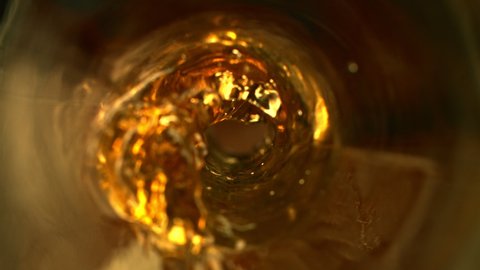 Super Slow Motion Abstract Shot of Pouring Golden Liquid in Glass Bottle at 1000 fps.
