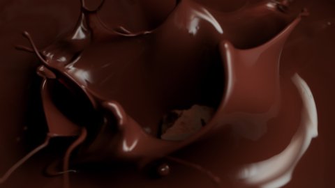 Super Slow Motion Shot of Raw Chocolate Chunks Falling into Melted Chocolate at 1000fps.