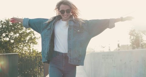 Stylishly dressed Blonde Woman having fun Outdoor in Jeans outfit. Looking Happy and Pleasant. Having Sunglasses , jumping and running in the Town. Looking gorgeous and great.