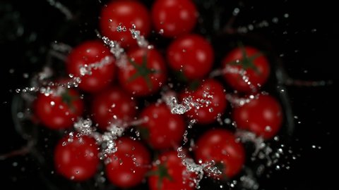 Exploding cherry tomatoes with water on a black background. Filmed on high speed cinema camera, 1000fps.