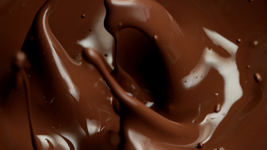 Super slow motion of flying raw chocolate pieces splashing into molten chocolate. Filmed on high speed cinema camera, 1000fps. Royalty-Free Stock Footage #1041679852