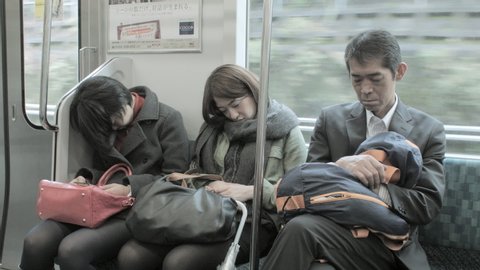 Tokyo / Japan - 09 23 2015: People sleeping on moving train in Japan after long day at work