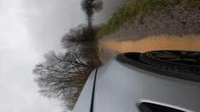 Vertical video. Car driving on a severe flooded road