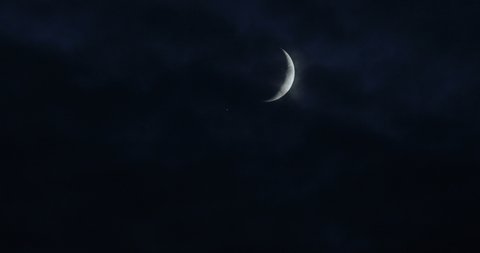 Clouds pass by the moon, winds blow during the storm.Details on the surface .A Crescent moon on a dark, cloudy night.  in a creepy feeling like a horror Thriller movie.dark night sky, black clouds.