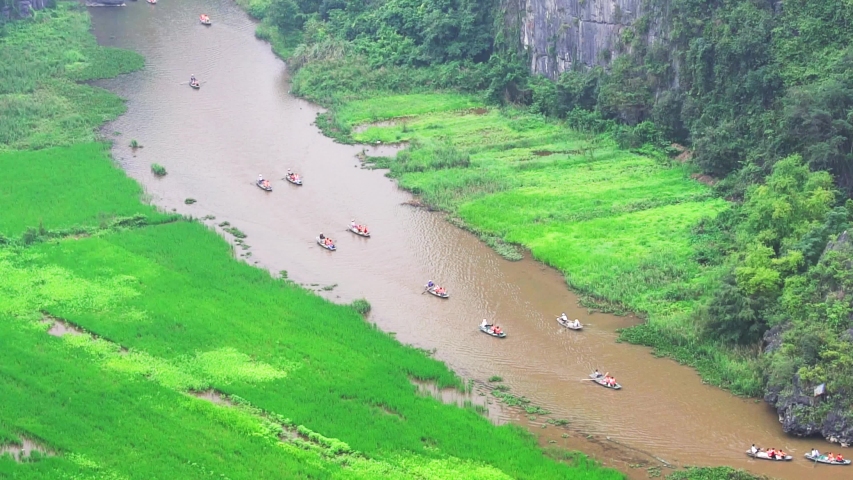 Tourist ride boat for sight seeing rice field on Ngo Dong river at Tam Coc, Ninh Binh, Vietnam