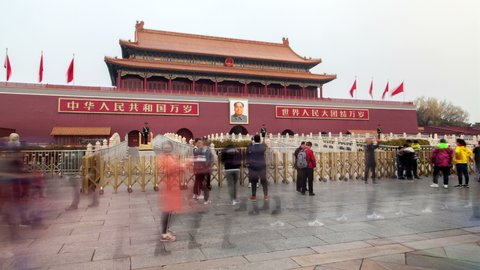 BEIJING/CHINA - MARCH 18 2019: Timelapse main Entrance Gate to famous Beijing Forbidden City palace complex decorated with Chinese former leader portrait and tourist crowds on paved square