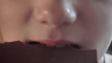 school boy eating chocolate bar.children's mouth closeup