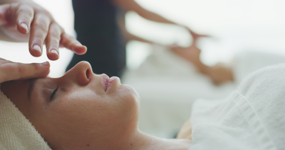 Close up of two young girlfriends with a towel on head are receiving a facial massage and spa treatment for perfect skin in a luxury wellness center. | Shutterstock HD Video #1041701830