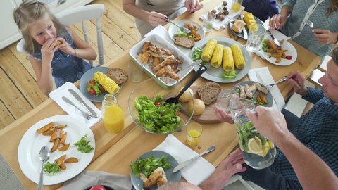 Top view of table with meals. eating, healthy, celebration, gathering concept. group of people having dinner at table with food. modern kitchen interior