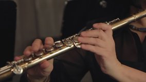 closeup of female hands playing flute in concert theatre orcherstra. classic music in theater. classical musician, brass instrument, , performer, flutist concept - Powered by Shutterstock - Get 15% off with code: PIKWIZARD15