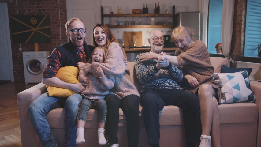 Excited family cheering in front of tv. big happy family watching sport match on tv feeling excited and thrilled.