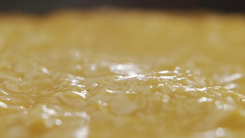 Macro shot of cheese sauce cooked in pan. Slow motion video processed cheese releases steam