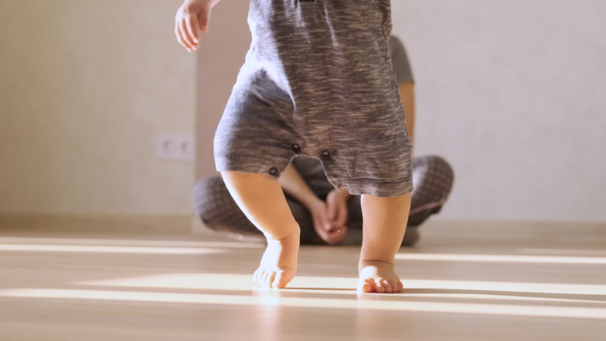 Little feet walking on floor, close-up. Baby learning to walk at home. Baby first steps. Slow motion Royalty-Free Stock Footage #1041723451