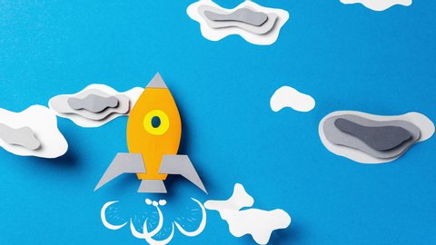 Rocket flies through the clouds, stop motion animation. Paper art. Business start up concept.
