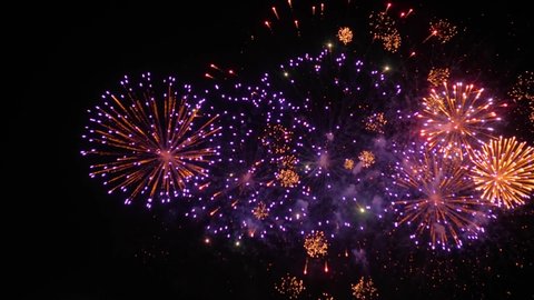 Holiday, celebration and anniversary concept. Colorful bright blurry fireworks in dark sky at night. Evening time, low light illumination. Slow motion shot