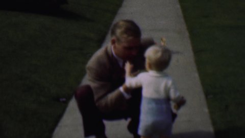 TERRA HAUTE INDIANA USA-1963: Older Man Blows A Whistle As A Little Boy Walks Away And Falls