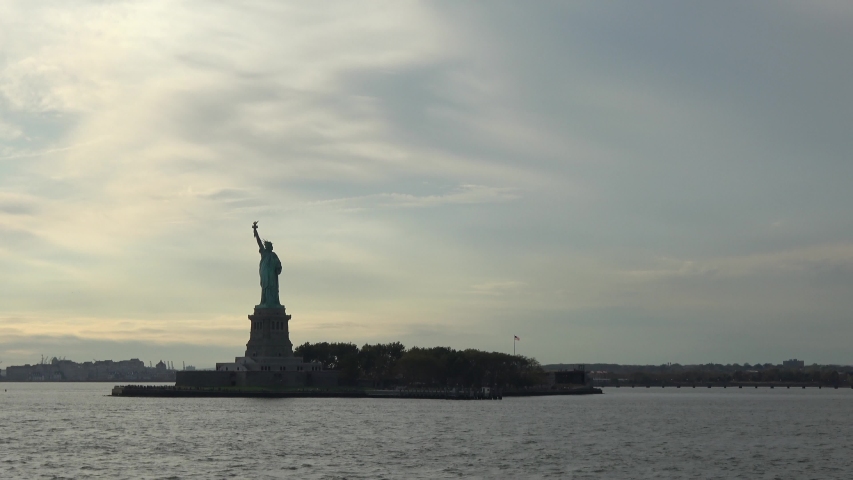 4K. Ultra HD. Zoom shot of the Statue of Liberty filmed at sunset from the East River, New York, United States of America. Statue of Liberty is one of the most famous monuments in New York.