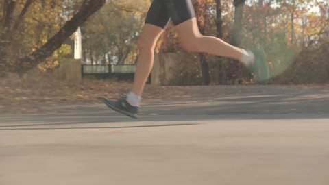 Runner Exercising In Sportswear Preparing To Triathlon And Sprinting Challenge.Running Silhouette On Road Half Marathon.Triathlete Foot Jogging For Marathon And Sprinting Training Running Competition.
