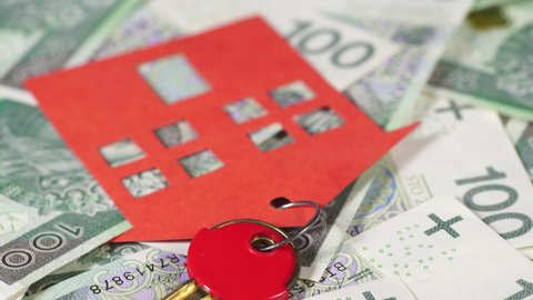 House key with red paper home model on polish zloty, one hundred banknotes. Real estate, savings money, property, investment concept